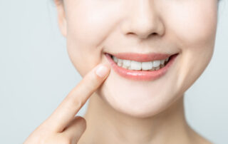 dental patient pointing to her smile