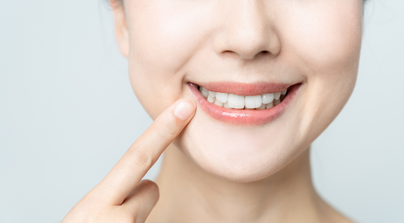 dental patient pointing to her smile