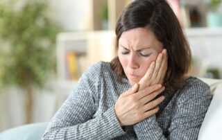 Middle age woman suffering from jaw pain at home
