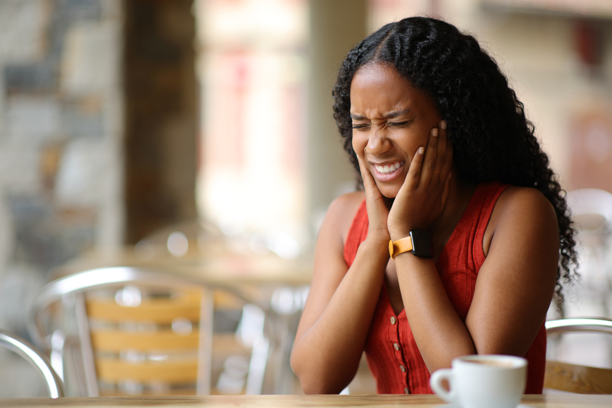 woman suffering tmj in a restaurant