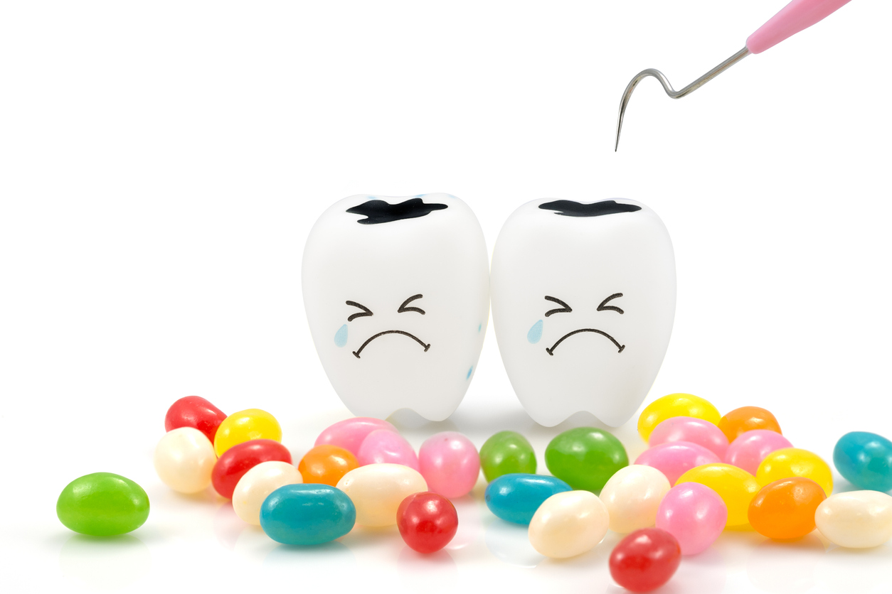 Teeth crying emotion with dental plaque cleaning tool and candy ,isolated on white background, With clipping path teeth and tool