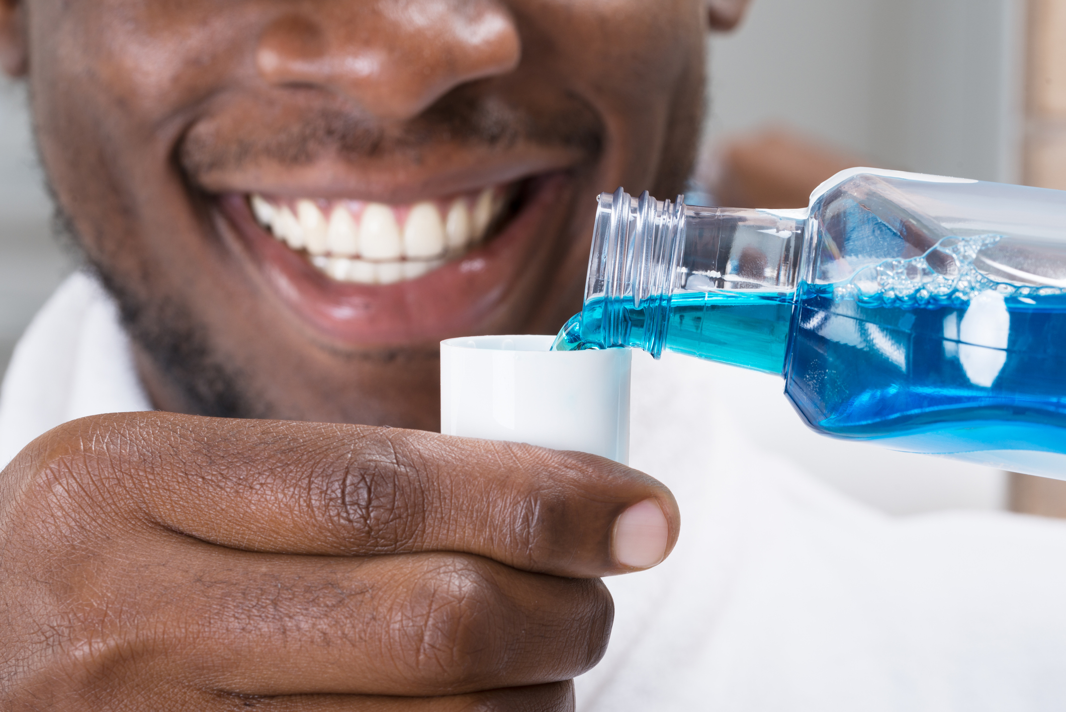 man pouring mouthwash